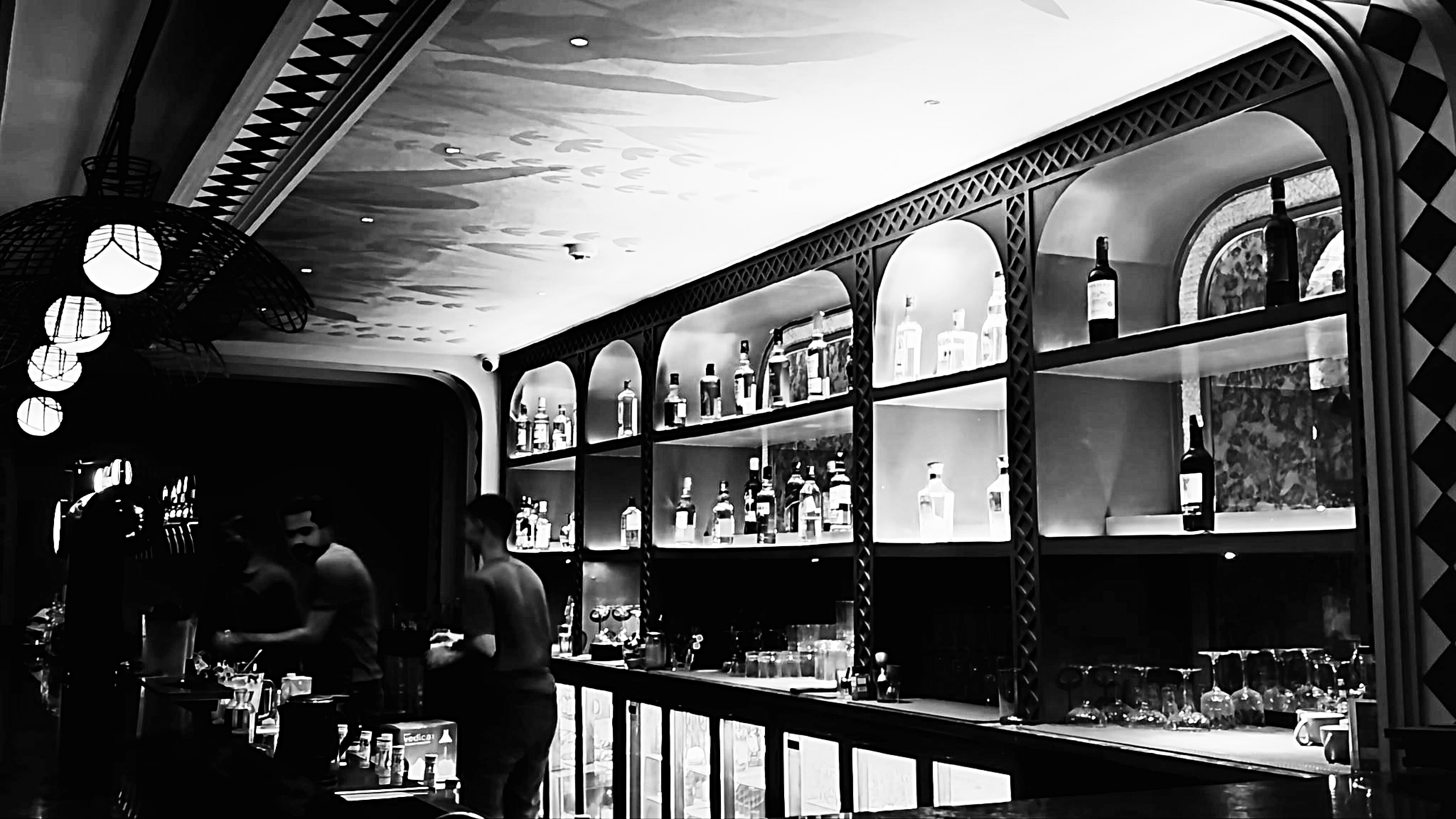 The Daysie bar interior with arched backlit bottle shelves and staff behind the counter